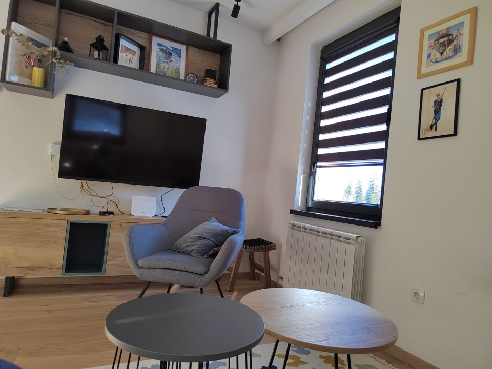 Televizor, fotelja i dva klub stolića