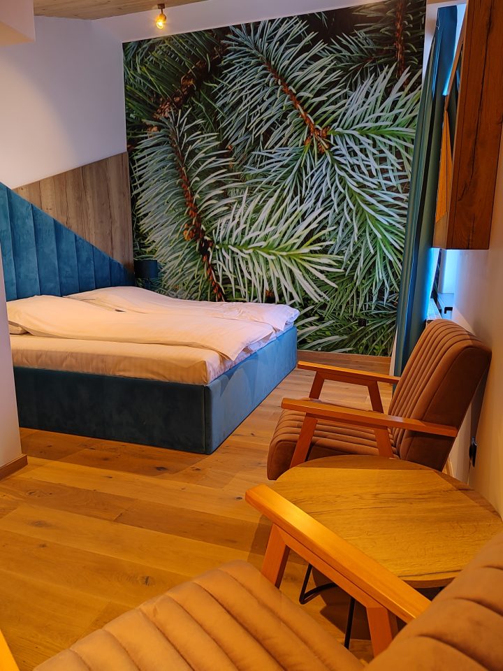 Spavaća soba sa foteljama i motivom četinara