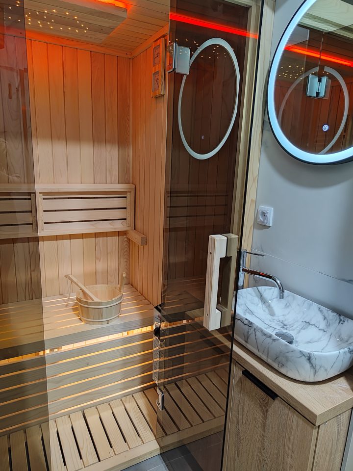 Sauna sa staklenim vratima pored lavaboa