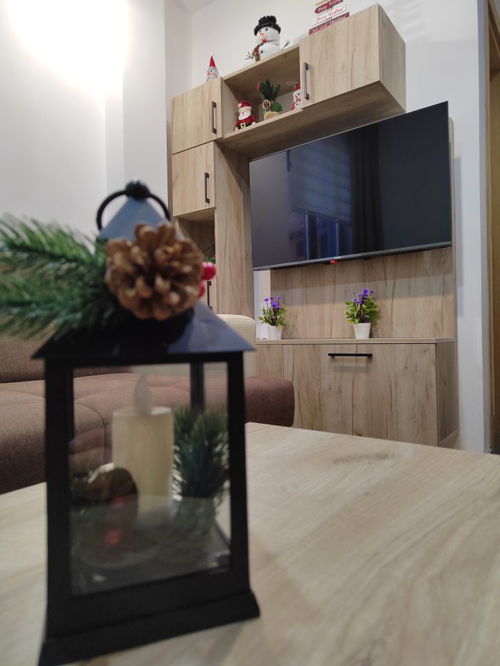 Ukrasni fenjer na stolu i TV zid